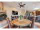 Bright dining area with a round glass table, comfortable seating, and a cozy fireplace at 5892 E Carefree Mountain Dr, Carefree, AZ 85377