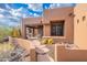 Desert home showcasing stone walkway, neutral stucco, desert landscaping, and covered patio at 5892 E Carefree Mountain Dr, Carefree, AZ 85377