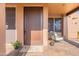 Inviting front porch with elegant door, flower pots, and desert decor, offering a warm welcome at 5892 E Carefree Mountain Dr, Carefree, AZ 85377