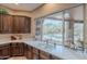 Kitchen sink area features beautiful dark wood cabinets and a view overlooking the backyard swimming pool at 5892 E Carefree Mountain Dr, Carefree, AZ 85377
