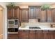 Stylish kitchen boasts dark wood cabinets, white countertops, and stainless steel oven and microwave at 5892 E Carefree Mountain Dr, Carefree, AZ 85377