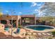 A stunning backyard featuring a sparkling pool with desert landscaping and comfortable seating areas at 5892 E Carefree Mountain Dr, Carefree, AZ 85377