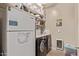 Well-organized laundry room with washer, dryer, refrigerator, and ample shelving for storage at 729 W Silver Reef Dr, Casa Grande, AZ 85122