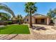 Beautiful backyard featuring artificial turf, palm trees, and a paved patio perfect for outdoor entertaining at 7365 W Magdalena Ln, Laveen, AZ 85339