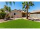 An inviting backyard showcasing artificial turf, mature palm trees, and a cozy patio area at 7365 W Magdalena Ln, Laveen, AZ 85339