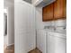 Well-equipped laundry area with a washer, dryer, and upper cabinets for storage space at 7365 W Magdalena Ln, Laveen, AZ 85339