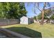 Spacious backyard featuring a storage shed, block fence, and lush green lawn for outdoor activities at 7719 N 17Th Ave, Phoenix, AZ 85021