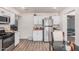 Modern kitchen with stainless steel appliances, white cabinets, and wood floors at 7746 W Osborn Rd, Phoenix, AZ 85033