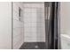Close up on a tiled shower with black and white tile and a shower curtain at 7746 W Osborn Rd, Phoenix, AZ 85033