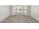 A carpeted bedroom provides a scenic view with a large bay window at 7924 W Hammond Ln, Phoenix, AZ 85043