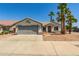 Charming single-story home with a gray two-car garage, desert landscaping, and mature palm trees at 7924 W Hammond Ln, Phoenix, AZ 85043