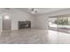 Open-concept living room with a fireplace, ceiling fan, and sliding glass doors to the pool at 7924 W Hammond Ln, Phoenix, AZ 85043