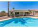Backyard pool area with palm trees and view of home's covered patio at 7924 W Hammond Ln, Phoenix, AZ 85043