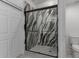 Modern glass shower adorned with a marbled design and pebble flooring at 7924 W Hammond Ln, Phoenix, AZ 85043
