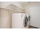 Efficient laundry room with washer, dryer, and convenient built-in shelving at 10226 E Pine Valley Rd, Scottsdale, AZ 85255