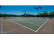 Well-maintained tennis court with blue and green surface, surrounded by a fence and lights at 10226 E Pine Valley Rd, Scottsdale, AZ 85255