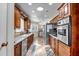 Well-lit kitchen featuring wood cabinetry, stainless steel appliances, and wood-look tile flooring at 10643 W Pineaire W Dr, Sun City, AZ 85351