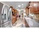 Kitchen with stainless steel appliances, wooden cabinets, tile backsplash, and wood-look flooring at 10643 W Pineaire W Dr, Sun City, AZ 85351