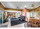 Spacious open-concept living room with a cozy seating area, dining table, and abundant natural light at 10643 W Pineaire W Dr, Sun City, AZ 85351