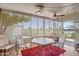 Bright sunroom with golf course views, comfortable seating and tile flooring at 10643 W Pineaire W Dr, Sun City, AZ 85351