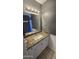 Bathroom with granite countertops, white cabinets, a mirror, and tile floors at 11026 N 28Th Dr # 34, Phoenix, AZ 85029
