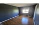 This bedroom features dark walls, wood-look flooring, and a window at 11026 N 28Th Dr # 34, Phoenix, AZ 85029
