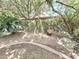 Landscaped backyard features mature trees and vines, and charming garden accents at 1118 E Orangewood Ave, Phoenix, AZ 85020