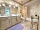 Classic bathroom with floral wallpaper, double sink vanity, bathtub/shower combo, and tile flooring at 1118 E Orangewood Ave, Phoenix, AZ 85020