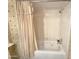 Cozy bathroom features a combined bathtub and shower with tiled walls and brass fixtures at 1118 E Orangewood Ave, Phoenix, AZ 85020