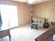 Bedroom featuring light colored carpet, wood paneled walls, and checkered sofa at 1118 E Orangewood Ave, Phoenix, AZ 85020