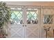 Bright doors with diamond pattern window panes and neutral window treatments offer backyard views at 1118 E Orangewood Ave, Phoenix, AZ 85020