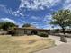 Charming single-story home featuring a brick facade, well-manicured lawn, and an arched entryway at 1118 E Orangewood Ave, Phoenix, AZ 85020