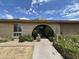 Close-up of the arched entryway, brick facade, and manicured landscaping around the front of the property at 1118 E Orangewood Ave, Phoenix, AZ 85020