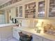 Bright kitchen with off-white cabinets, glass-front displays, and a built-in desk area at 1118 E Orangewood Ave, Phoenix, AZ 85020