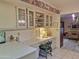 Bright kitchen with off-white cabinets, glass-front displays, built-in desk area, and an open layout to the dining room at 1118 E Orangewood Ave, Phoenix, AZ 85020