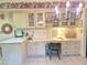Bright kitchen featuring off-white cabinets, glass-front displays, and a cozy built-in desk area with a chair at 1118 E Orangewood Ave, Phoenix, AZ 85020