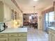 Bright kitchen with off-white cabinets, glass-front displays, built-in desk area, and an open layout to the dining room at 1118 E Orangewood Ave, Phoenix, AZ 85020