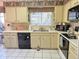 Bright kitchen with window view over the sink, black dishwasher and appliances and tile floor at 1118 E Orangewood Ave, Phoenix, AZ 85020