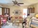 Inviting living room with a comfortable sofa, red wingback chair, ceiling fan, and warm lighting at 1118 E Orangewood Ave, Phoenix, AZ 85020