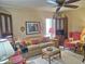 Inviting living room with a comfortable sofa, red wingback chair, ceiling fan, and warm lighting at 1118 E Orangewood Ave, Phoenix, AZ 85020