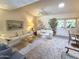 Spacious living room boasting plush carpet, comfortable seating, and ample natural light through French doors at 1118 E Orangewood Ave, Phoenix, AZ 85020