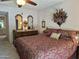 Comfortable main bedroom with a ceiling fan, dresser with mirrors, and a peek into the main bathroom at 1118 E Orangewood Ave, Phoenix, AZ 85020
