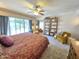 Bright main bedroom featuring a ceiling fan, slider access to backyard and a decorative shelf at 1118 E Orangewood Ave, Phoenix, AZ 85020