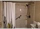 Bathroom shower with neutral colored tile, shower head, grab bar, and cactus themed shower curtain at 1118 E Orangewood Ave, Phoenix, AZ 85020