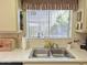 Bright kitchen view of double sinks, large window with blinds and vintage decor at 1118 E Orangewood Ave, Phoenix, AZ 85020