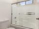 Bathroom featuring white tiled shower with a glass door, offering a clean and modern design at 11182 W Coronado Rd, Avondale, AZ 85392