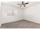 Carpeted bedroom with ceiling fan, window, and neutral walls at 11182 W Coronado Rd, Avondale, AZ 85392