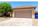 Two-car garage with tan door on a single-story home with desert landscaping at 11182 W Coronado Rd, Avondale, AZ 85392