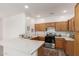 A bright kitchen features wooden cabinetry, quartz countertops, and stainless steel appliances at 11182 W Coronado Rd, Avondale, AZ 85392