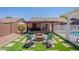 Backyard view featuring patio, fire pit, outdoor seating, artificial turf and pool at 11252 E Edgewood Ave, Mesa, AZ 85208